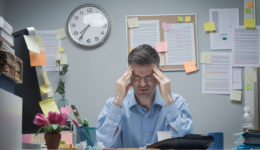 Office-Worker-With-Headache-75399391