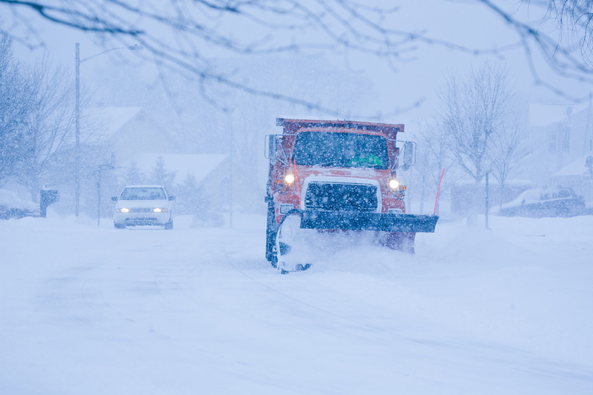 Heavy snowfall and a car behind the snowplow Heavy snowfall and a car behind the snowplow
