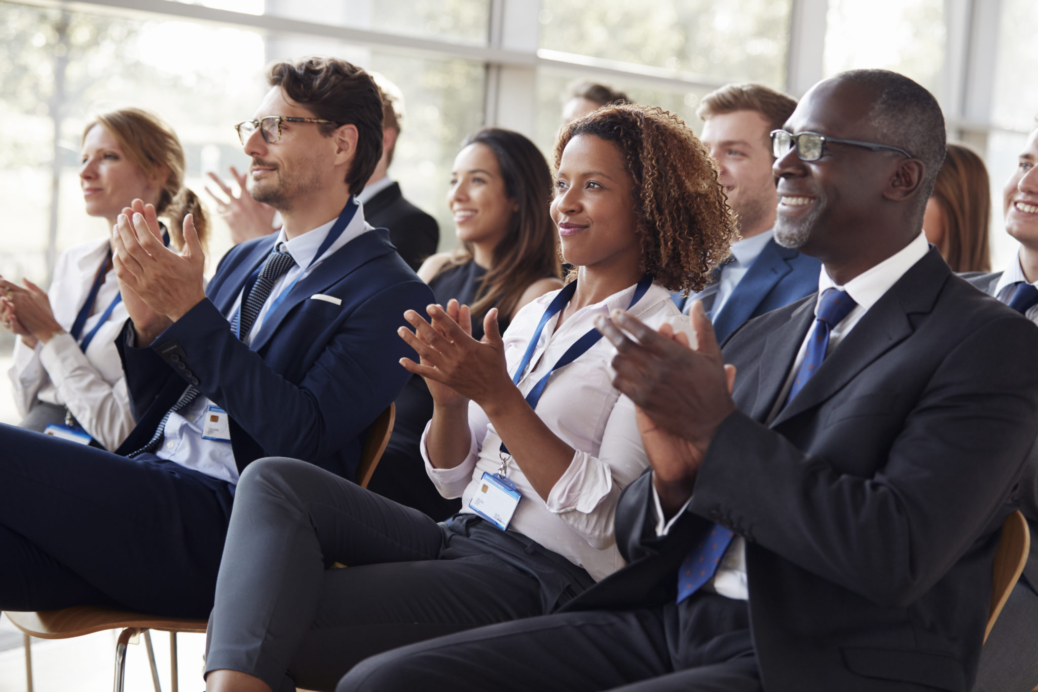 Smiling audience applauding at a business seminar Smiling audience applauding at a business seminar